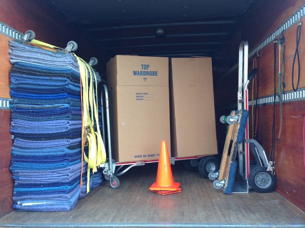 Inside a Seattle's Best Moving truck stocked with double quilted furniture pads, dollies, hand trucks, straps, and wardrobe boxes